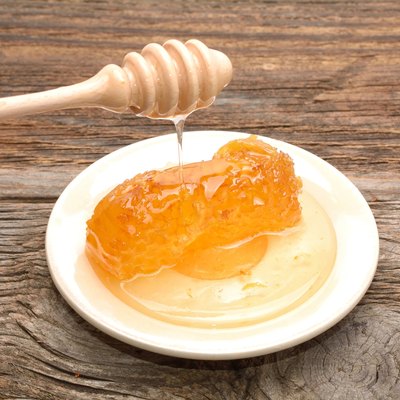 Honey with honeycomb on wooden table