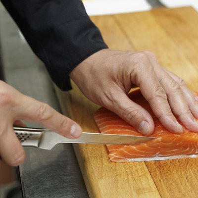 Chef is slicing salmon fillet