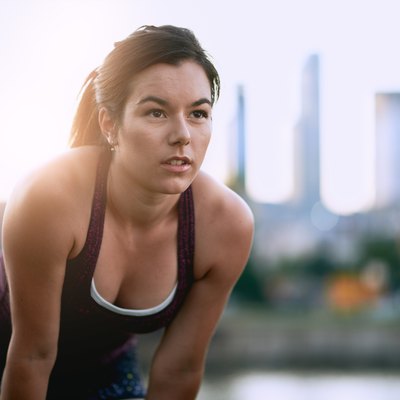 Portrait of active millenial woman jogging at dusk with an