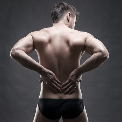 Man with backache on gray background