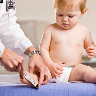 Doctor giving baby girl checkup on an examination table