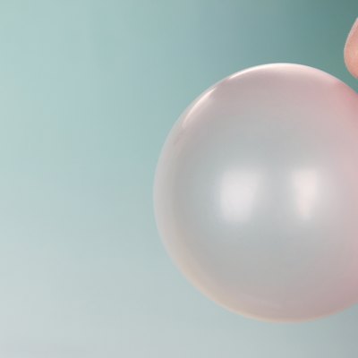 Person doing bubble with chewing gum on bright background