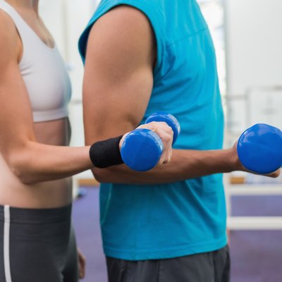 Fit couple exercising with blue dumbbells