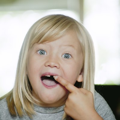 Portrait of girl (6-7) showing her missing tooth
