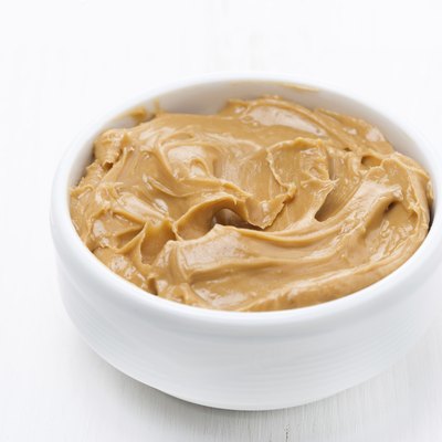 bowl of peanut butter on white wooden table