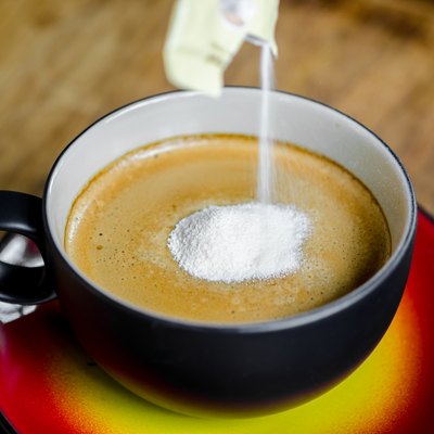 Creamer in to a cup of coffee.