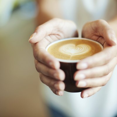 Closeup of Female giving coffee with heart symbol