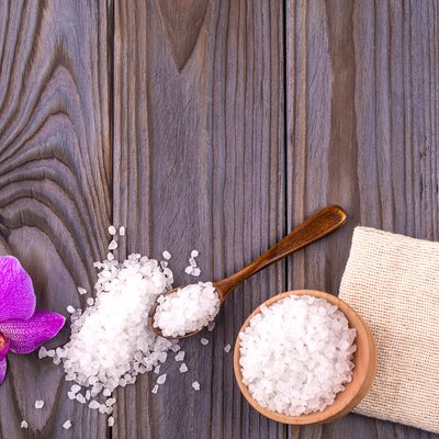 White bath salt in a wooden bowl
