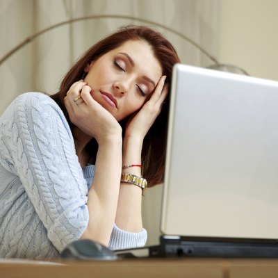 Tired woman with closing eyes sitting on her workout