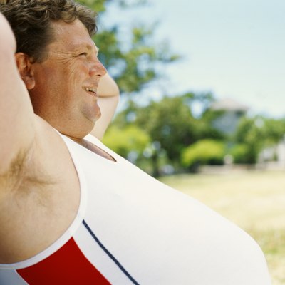side profile of a mid adult man leaning against a tree