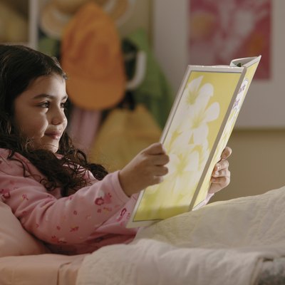 Girl reading book in bed