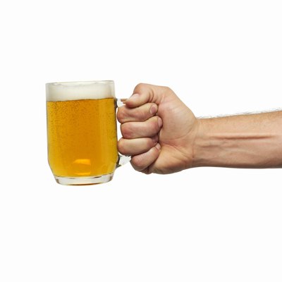 Close-up of man's hand holding glass of beer