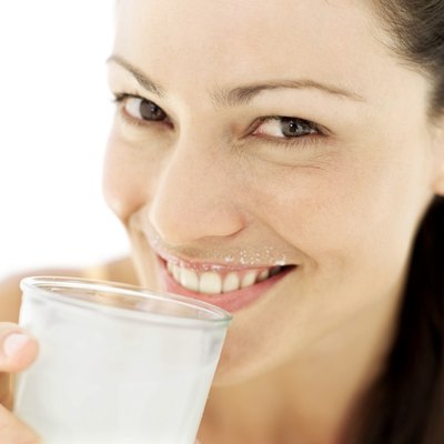 close-up of a young woman drinking a glass of milk