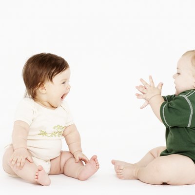 Female baby (6-9 months) laughing, baby boy clapping hands