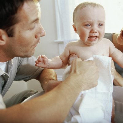 Close-up of parents giving their son a bath