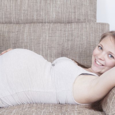 Pregnant Girl is laying on a sofa