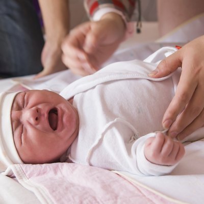 Newborn baby crying on the bed