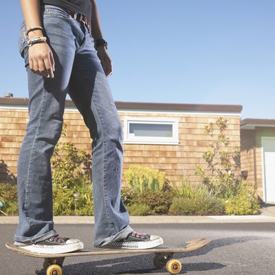 Low section view of a teenage girl skateboarding on the street
