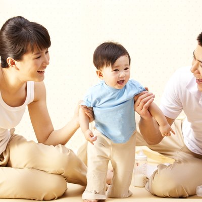 Mother and father teaching baby to walk