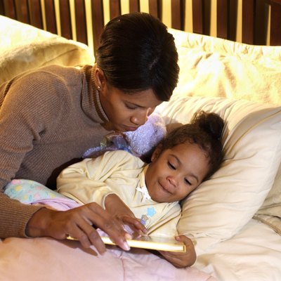 Mother reading bedtime story to daughter