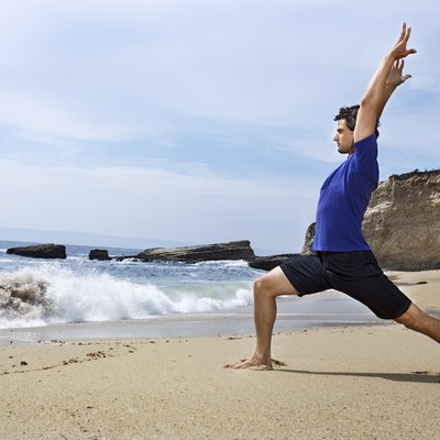 Man doing yoga on beach