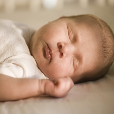 Close-up of a newborn baby sleeping on the bed