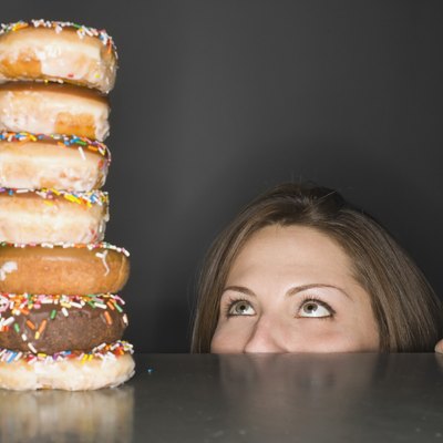 Woman looking at stack of donuts in awe
