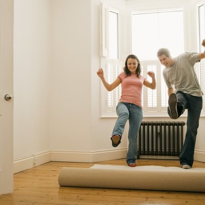 Couple unrolling carpet