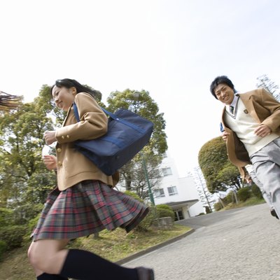 Three high school students running, low angle view, Japan