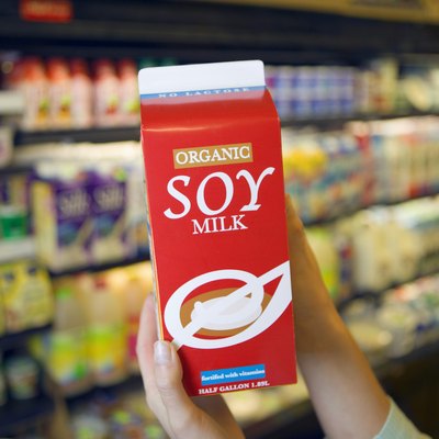 Person holding carton of soy milk