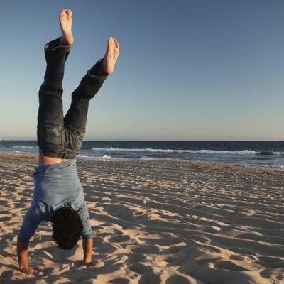 Man doing handstand on beach