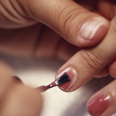 Close-up of a person's hands applying nail polish
