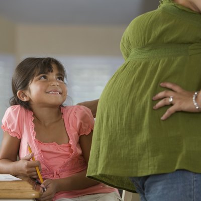 Hispanic girl smiling at pregnant mother