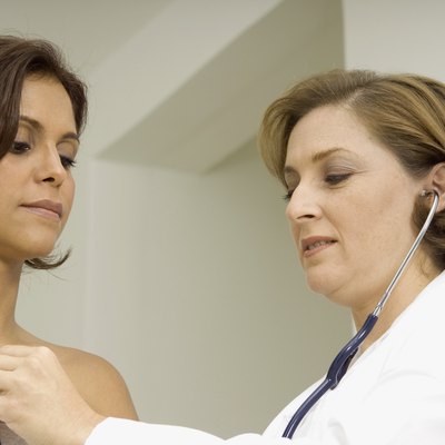 Female doctor examining a mid adult woman with a stethoscope