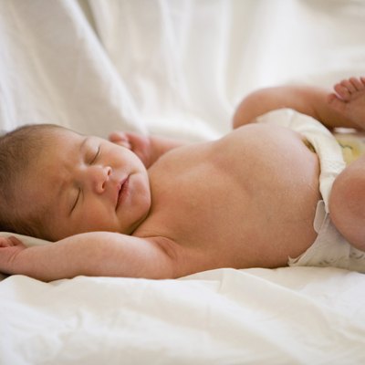 Newborn baby lying on bed