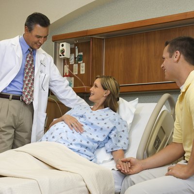 Husband and pregnant wife in hospital with doctor
