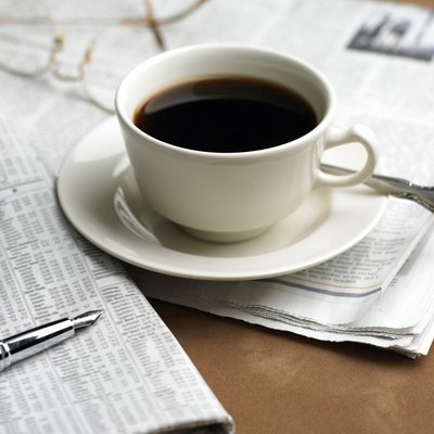 Cup of coffee, pen and financial newspaper