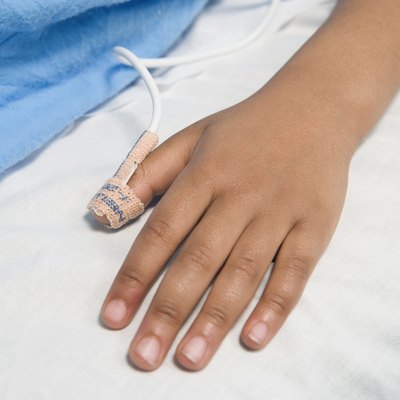 Close up of African child's hand with IV on hospital bed