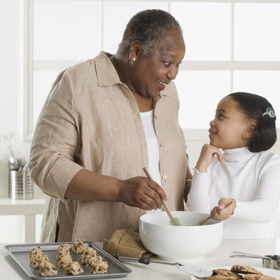 Senior woman making cookies with her granddaughter
