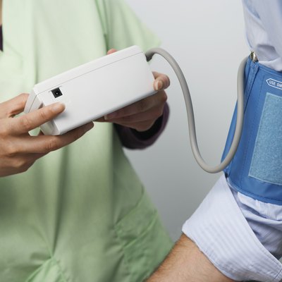 Doctor checking patients blood pressure,close-up