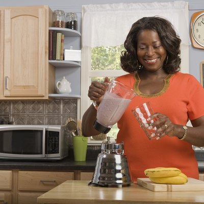 Woman in kitchen making smoothie