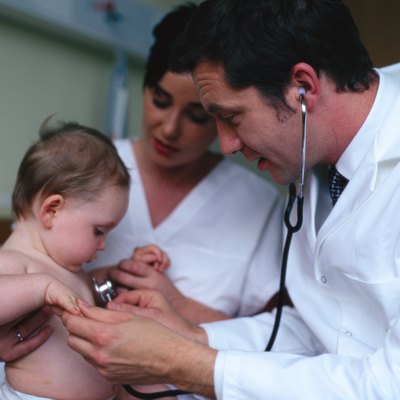 A male doctor examining a baby with a stethoscope