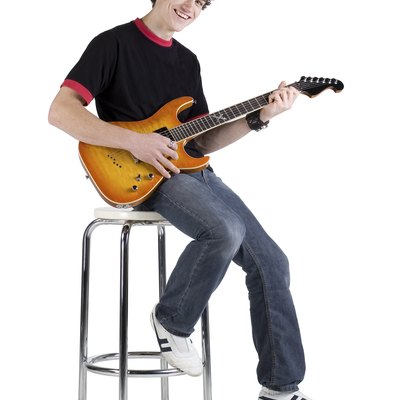 Teenage musician sitting on stool