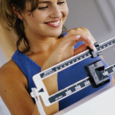 Close-up of a young woman adjusting a weight scale