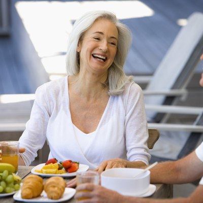 Couple laughing by plates of fruit