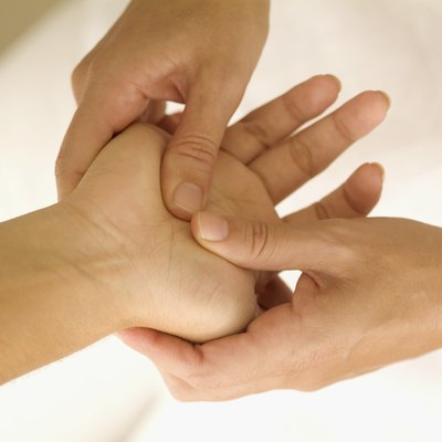 One person's hand inside another's, with fingers pressing on palm