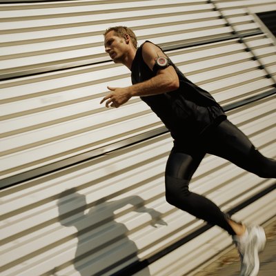 Man running past warehouse building (blurred motion)