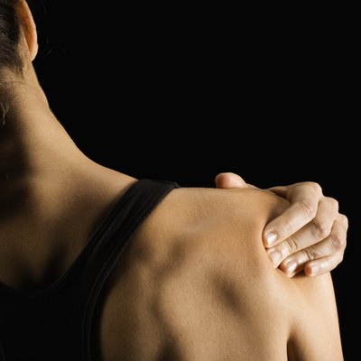 Woman rubbing shoulder, rear view
