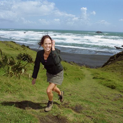 Woman walking up hill, beach in background