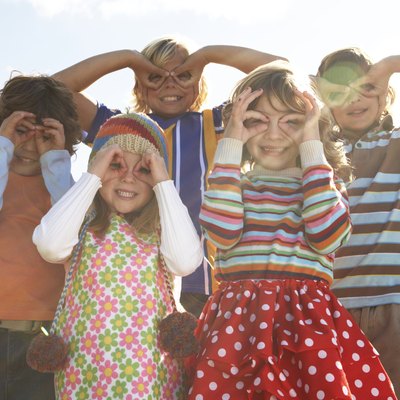 Five children (7-12) with fingers over eyes, portrait (lens flare)